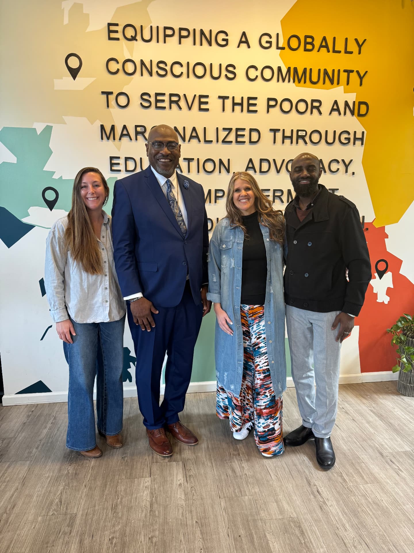 Members standing together in front of the church mission statement wall